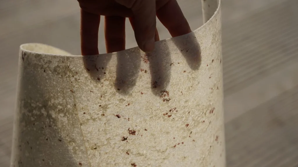 A hand bending a sheet of River White stone veneer